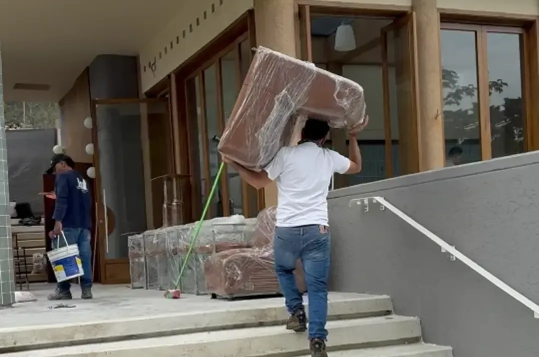 Persona cargando un sofá para un restaurante